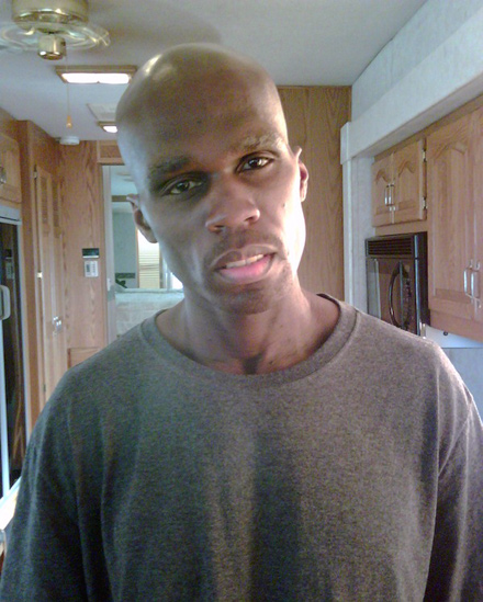 A very slim 50 Cent posing in a kitchen, 54 pounds lighter