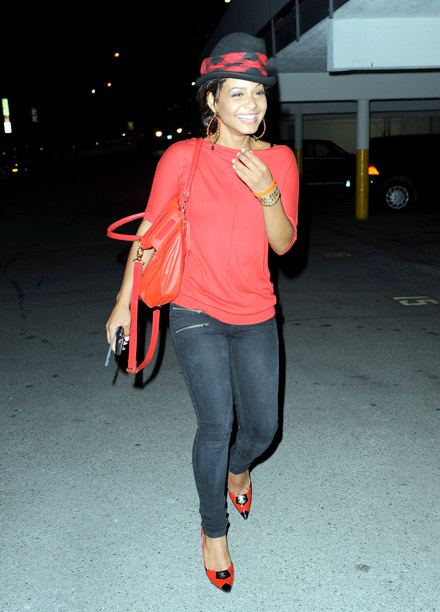 Christina Milian laughing in her little black and red top hat