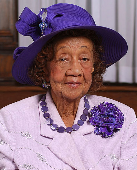 Dorothy Height styling in a purple dress and royal purple hat