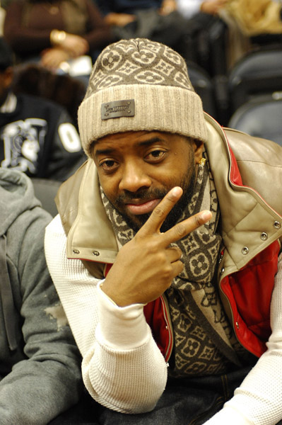 Jermaine Dupri throws the peace sign at a Hawks/Nuggets game
