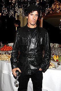 Steven Klein in a leather jacket, with glass of wine in hand