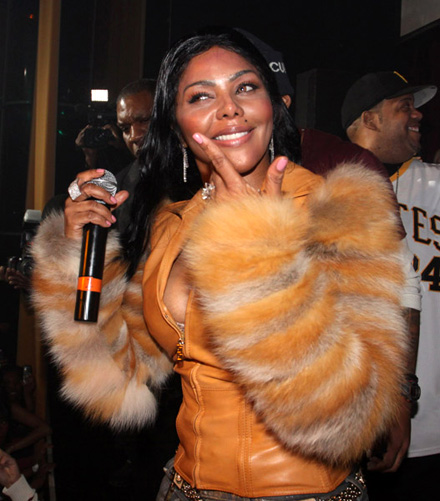 Lil Kim in tan fur and leather jacket on stage at M2 Mansion
