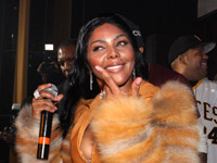 Lil Kim in tan fur and leather jacket on stage at M2 Mansion