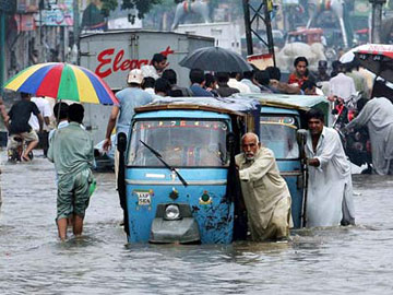 Pakistan - Cyclone Yemyin - Man pushing car through flooded street