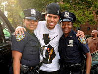 Chris Brown poses with female police officers at Rucker Park