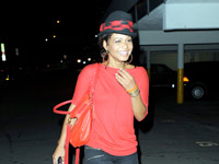 Christina Milian laughing in her little black and red top hat