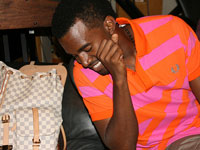 Kanye West in the studio, in a pink and orange shirt