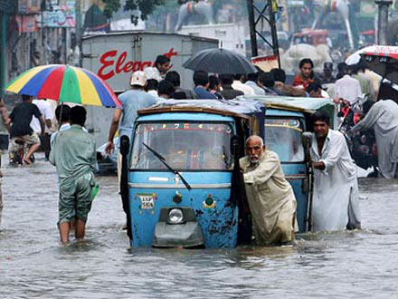 Pakistan - Cyclone Yemyin - Man pushing car through flooded street